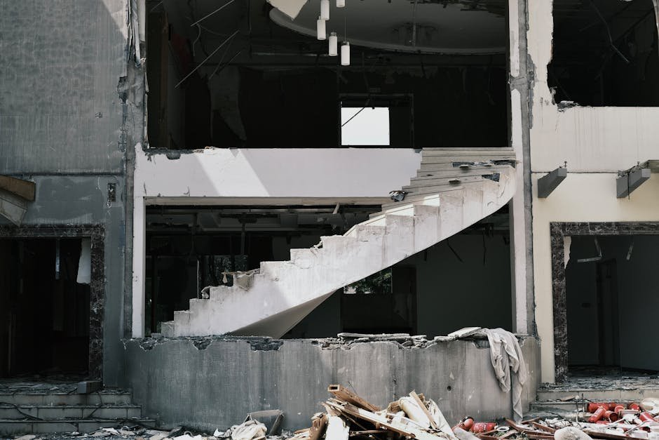 An abandoned urban building with a partially destroyed staircase, conveying desolation.