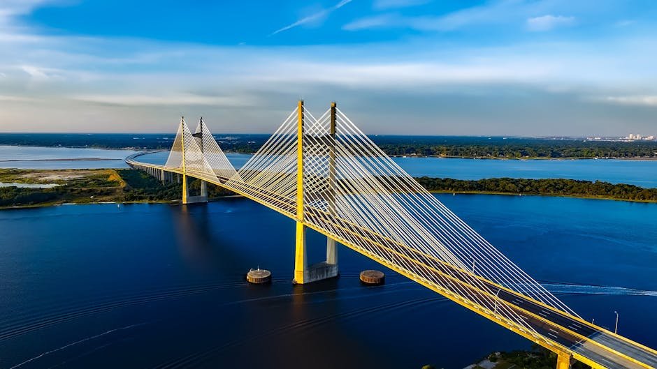 Stunning aerial shot of the Dames Point Bridge spanning over blue waters under a clear sky.