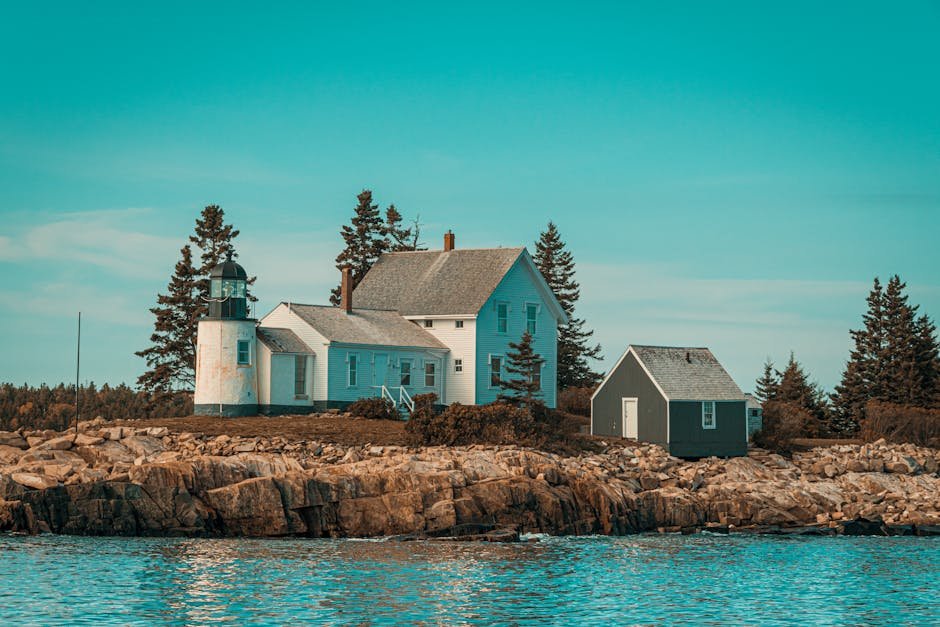 Scenic view of a coastal lighthouse and house on rocky shores in Maine, USA. Ideal for travel inspiration.