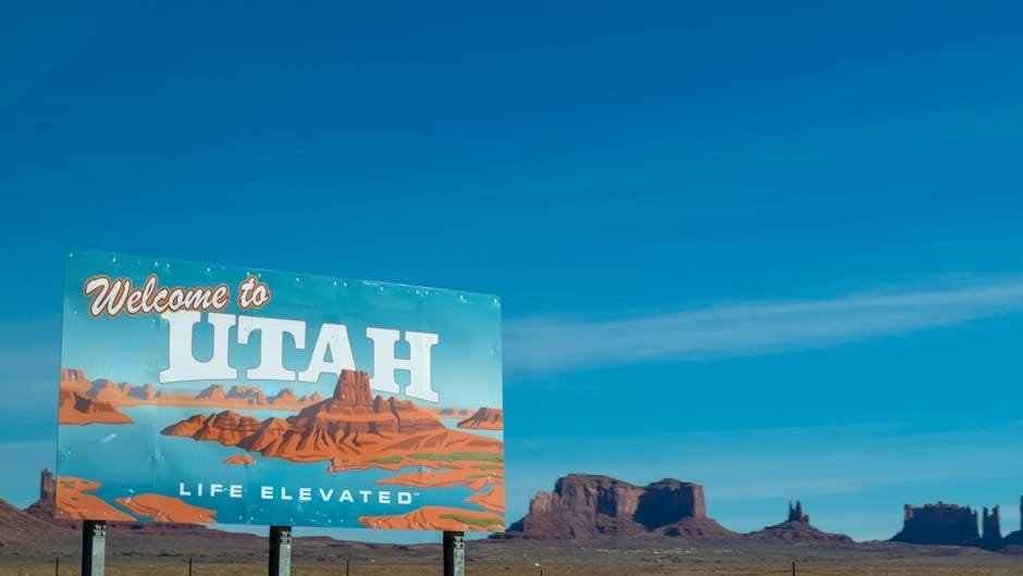 Best Insurance in Utah 2025 02/22/2026 Scenic view of Utah welcome sign against desert and blue sky backdrop.