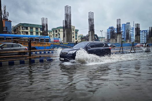 Flood Insurance vs. Home Insurance: What’s the Difference and Why It Matters in 2025 02/22/2026 Flooded street scene in Kolkata with vehicles navigating heavy monsoon rainwater. Urban landscape during rainy season.