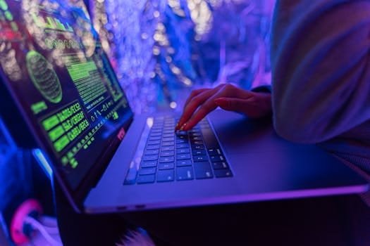 Ransomware Insurance for Healthcare Businesses in 2025: What You Must Know 02/22/2026 Close-up of hands typing on a laptop displaying cybersecurity graphics, illuminated by purple light.